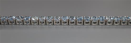 A 750 white metal and aquamarine set line bracelet, 18.2cm.